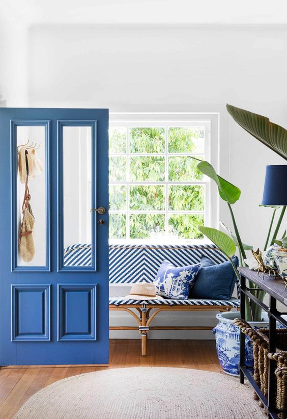 a classic blue door and a matching lamp plus a striped bench will make your entryway fresh and bold