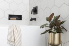 13 oversized white hexagon tiles accented with black grout for a chic and bold bathroom look with a modern feel