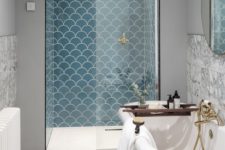 14 blue scallop tiles accent the shower space and make it stand out with their color and shapes