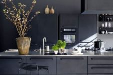 15 a contemporary moody kitchen with black cabinetry of metal and white countertops plus a metal stool