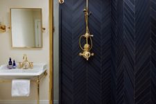 15 black herringbone tiles and a brass fixture make the shower space really stand out and look bold