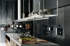 16 a moody mini,alist kitchen done in the shades of grey, with a large kitchen island and overhead shelves