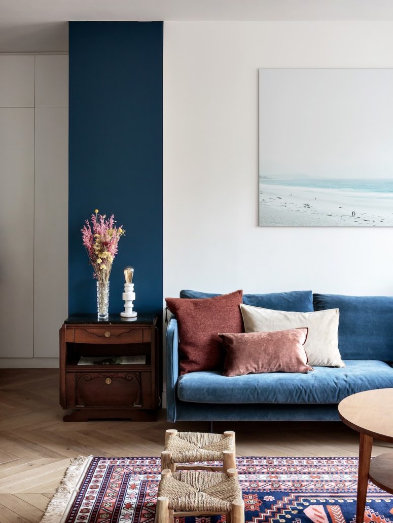 a touch of classic blue brought with a sofa and highlighted with a teal stripe on the wall