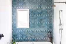 20 a bright bathroom with geometric blue tiles all over that make the bathing space stand out