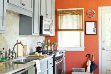 21 a chic vintage-inspired kitchen in dusty blue with a rust-colored accent wall that rocks