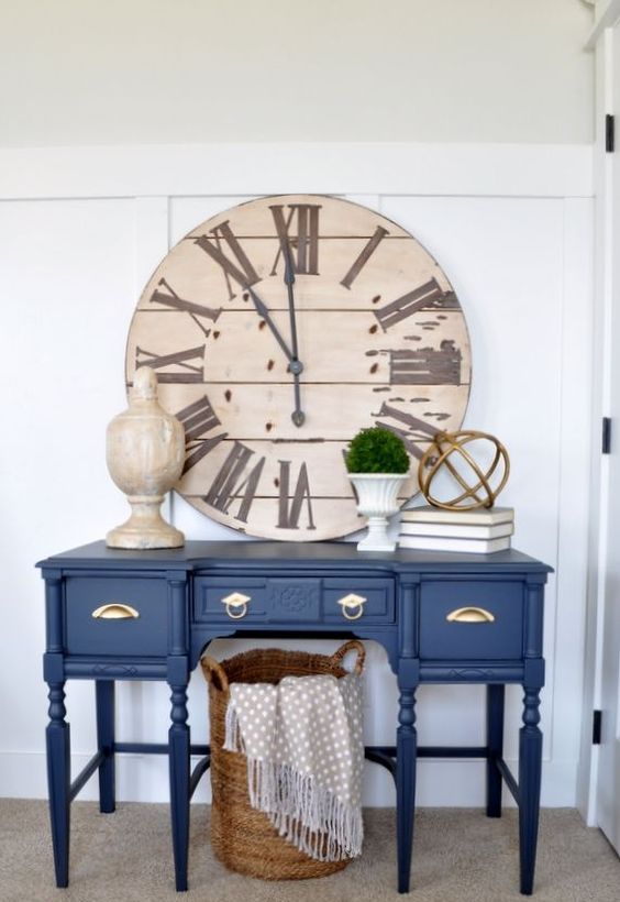 an entryway done with a classic blue console that brings a trendy and bold touch to the room