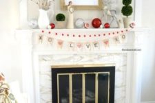 a Valentine fireplace with silver and red ornaments, branches with red hearts, topiaries