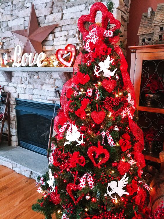 a Valentine tree with white angels, lights, red glitter hearts and red ribbons plus berries