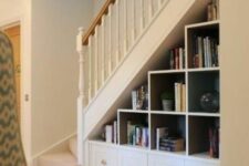 a built-in storage unit with open storage compartments and drawers is an elegant addition to the staircase