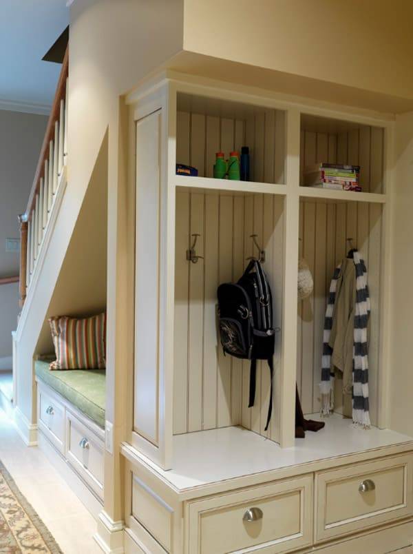 a built-in under stairs mudroom with shelves and drawers, pillows and various things is a cool idea to save space
