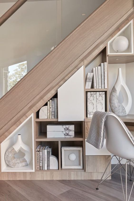 a compact storage unit that matches the staircase, with open storage compartments and some decor
