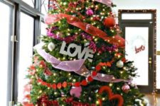 a gorgeous Valentine tree with pink and red ribbons, lights, LOVE letters and heart decor looks wow