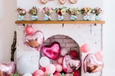 a gorgeous and sassy Valentine fireplace with lots of pink balloons, lush blooms in vases and on the mantel