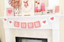 a simple Valentine mantel with red branches, ombre trees, a cool garland and lots of photos