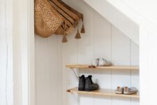 a small mudroom with wooden shelves and hanging baskets is a cool space to be in, it’s hidden in a smart way