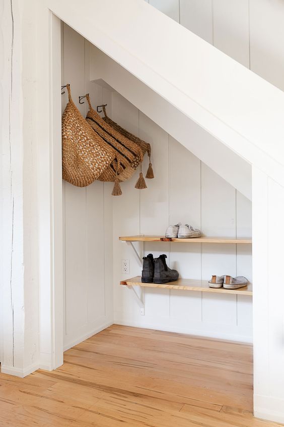 a small mudroom with wooden shelves and hanging baskets is a cool space to be in, it's hidden in a smart way