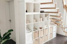 a smart storage unit of open compartments and drawers is a cool idea for a staircase