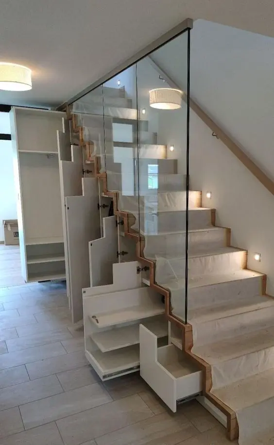 a staircase with built-in drawers and storage units is a very modern and smart solution for a space