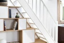 a stylish storage unit with shelves and storage compartments is a stylish addition for the space under the stairs