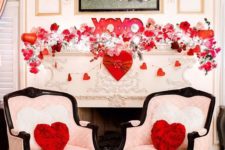 a very lush and formal Valentine fireplace with lots of light, heart and floral garlands, XO letters and heart throws