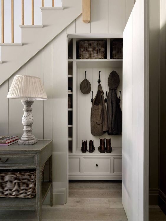 an elegant vintage under stairs mudroom with a built-in storage system and drawers plus baskets is a cool idea for a cozy vintage space