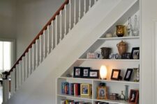 an open storage under built into the staircase is a cool bookcase that doesn’t require any floor space