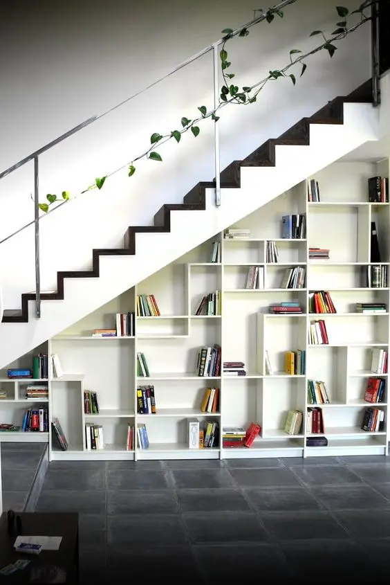 an open storage unit built into the staircase is a cool idea and you may use it as a bookcase if you want