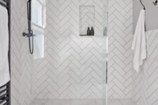 07 a contemporary bathroom with large scale marble tiles on the floor and herringbone tiles on the walls