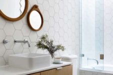 07 white hex tiles with black grout on the walls, a floating vanity and a duo of mirrors in wooden frames for an interesting look