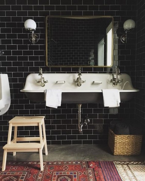 black subway tiles with white grout look chic and refined and a black vintage sink match the tiles