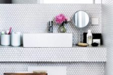 11 white penny tiles in the sink zone make it eye-catchy and very modern, the grout matches for a harmonious space