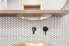 12 white penny tiles with black grout and fixtures and a brass bowl sink look very chic