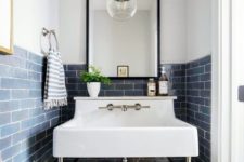 13 a small sink space clad with blue subway tiles and white grout plus a vintage sink and a pendant lamp