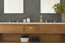 13 black penny tiles with white grout, a stained wooden vanity and a marble countertop for a chic and elegant look