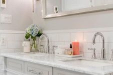 14 a neutral and elegant sink space with white subway tiles, a marble countertop and silver touches here and there