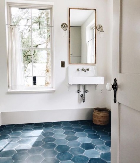 blue hex tiles in various shades of blue with white grout on the floor and white serene walls make up a relaxing space