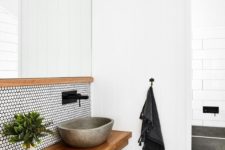 15 a contemporary bathroom with white penny tiles and black grout, a floating wooden vanity and a concrete sink