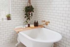 17 a modern airy bathroom with white subway and penny tiles on the floor plus greenery to refresh the space
