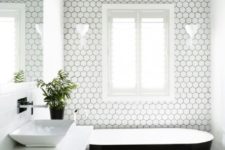 21 a monochromatic bathroom with small white hex tiles with black grout accentuate the bathtub space