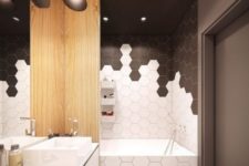 22 white and black hexagon tiles clad in a catchy and bold pattern to highlight the bathtub zone