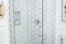 24 a neutral shower done with white hex tiles on the walls and black mini hex tiles on the floor