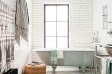 24 retro-inspired bathroom with white subway tiles and hex ones with black grout and a mint free-standing bathtub