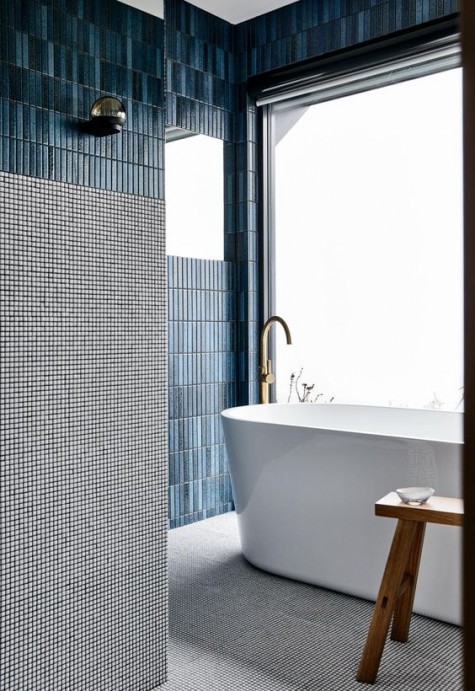 narrow and long blue tiles on the walls and grey printed tiles on the floor for a cohesive and harmonious look