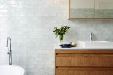 25 soft aqua color subway tiles create a very relaxing bathroom, and warm woods add coziness to it