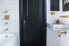26 white subway tiles and mosaic monochromatic tiles on the floor and a black door for a monochromatic space