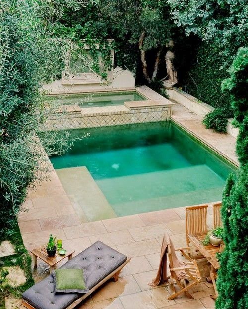 a Moroccan backyard with a plunge pool, a hot tub, wooden furniture and warm colored tiles