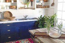 a boho chic kitchen with wooden and wicker touches plus a colorful boho rug and bold cabinets