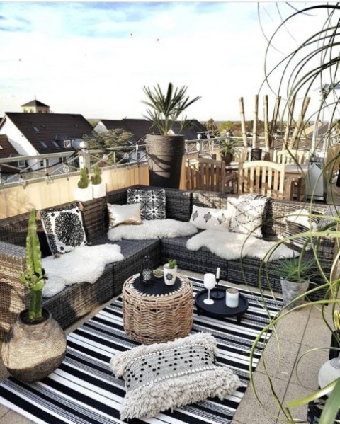 a boho rooftop terrace in a monochromatic color scheme, with Moroccan patterns and potted desert plants