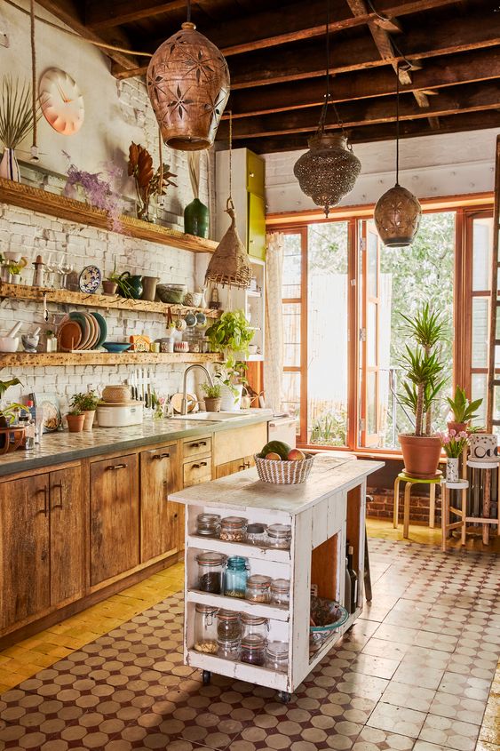a boho tropical kitchen with wooden cabinets, a white kitchen countertops, wicker and metal lampshades and a brick wall