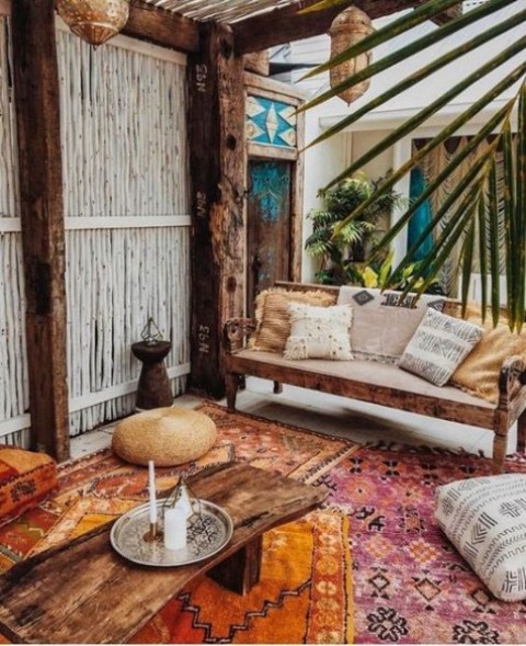 a bright boho Moroccan terrace with Moroccan lanterns, floor cushions, colorful printed textiles and candles